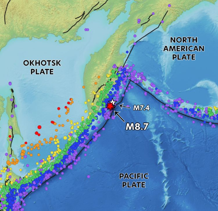 Map showing the tectonic setting of the Kamchatka Peninsula region. The Pacific Plate subducts beneath the Okhotsk Plate at the Kuril-Kamchatka Trench. A red star marks the epicenter of the July 29 magnitude 8.7 earthquake offshore, with a nearby white star indicating the earlier July 20 magnitude 7.4 earthquake. Colored dots along the plate boundaries represent historical earthquakes, with different colors denoting earthquake depth. Plate boundaries and labels for the Pacific, Okhotsk, and North American Plates are also shown.