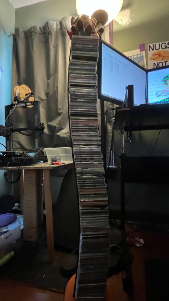 A melody nosurname plushie on a stack cds