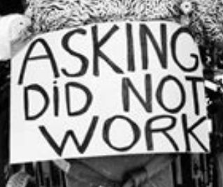 A sign that says asking did not work on the back of a wheelchair.