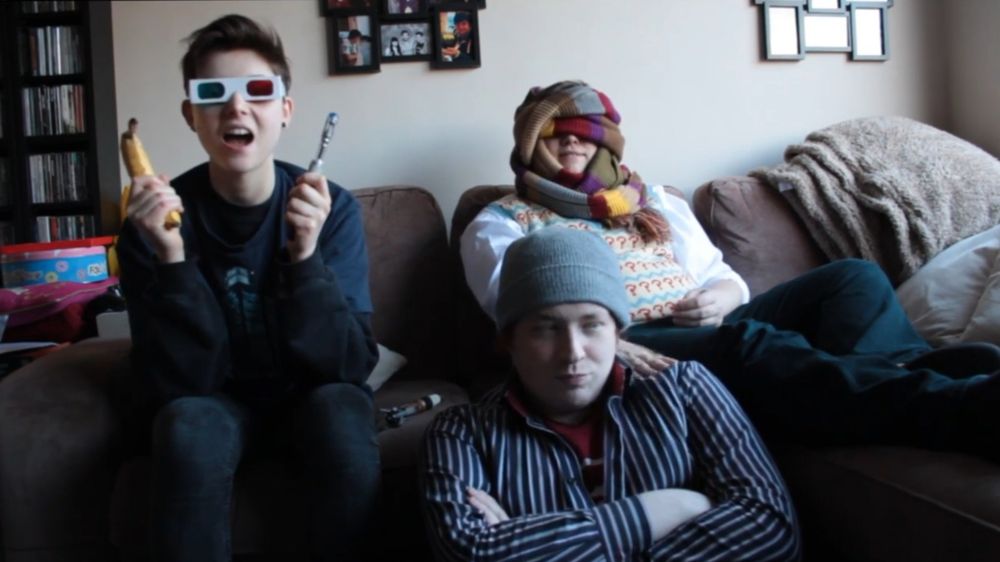 Three Doctor Who fans sat on a sofa. It's Christel, Richard and Chris from the FiveWhoFans video "How to Watch Doctor Who."