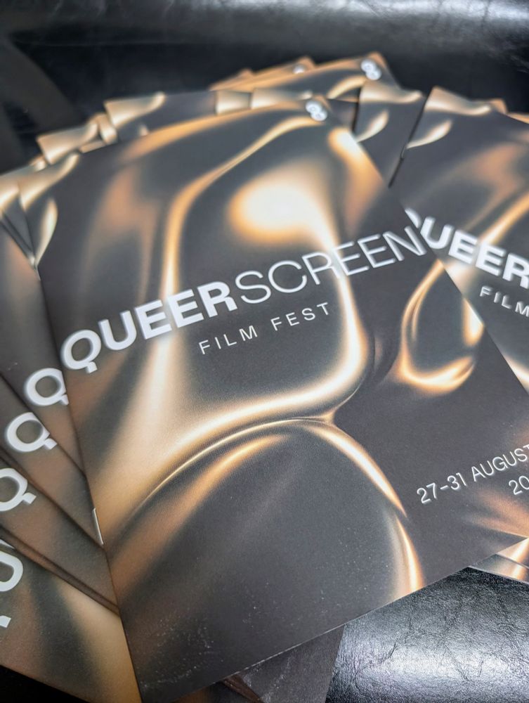 A pile of booklets with the text "Queer Screen Film Fest: 27-31 August, 2025" on the cover