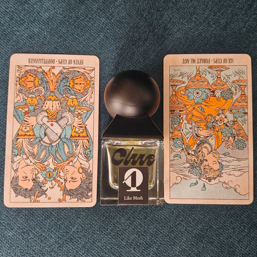Reversed VII of Cups - Doppelganger and VI of Cups - Forget-Me-Not straddle a bottle of Like Mesh by Laura Oberwetter for Clue Perfumery