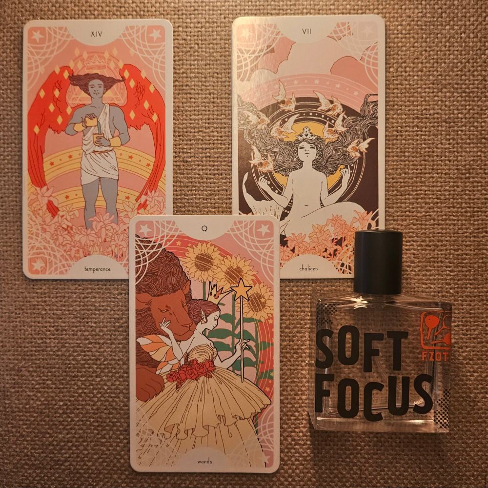 Cards XIV - Temperance, VII of Chalices, and the Queen of Wands sit arrayed next to a bottle of Soft Focus by Bruno Fazzolari for Fzotic