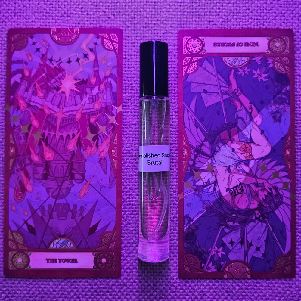 Card XVI - The Tower and a reversed IX of Swords straddle a decant of Brutal by Demolished Studio