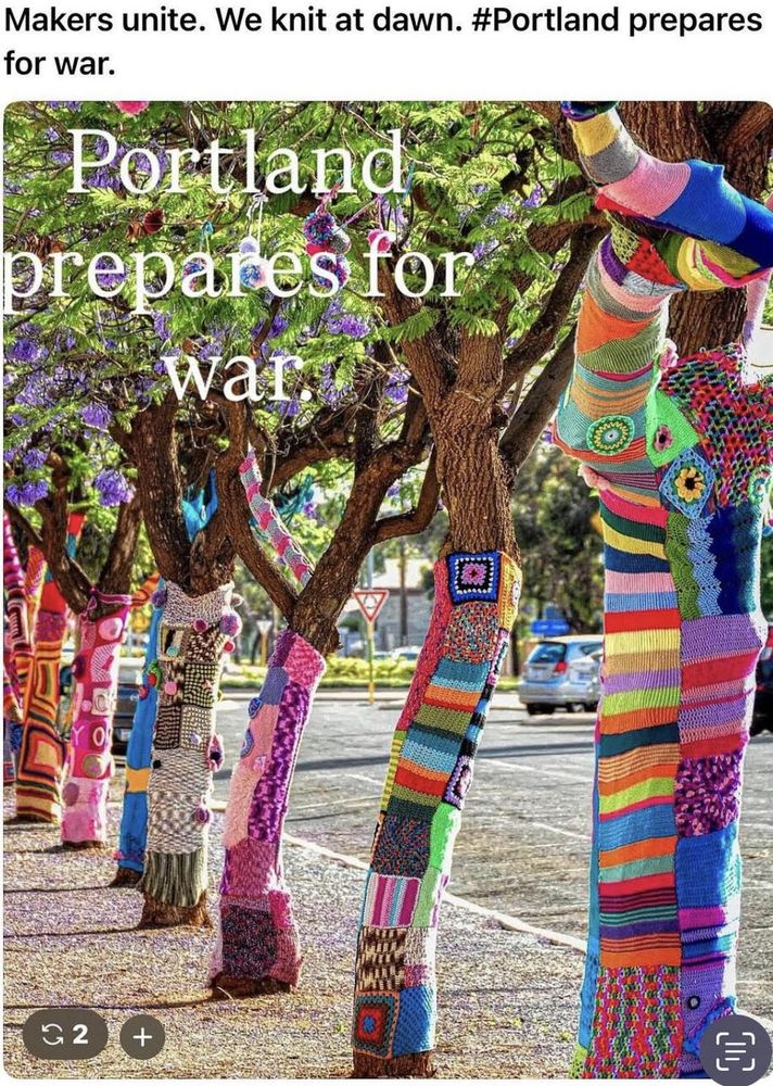 A street with lined trees in a Portland neighbor hood with hand knitted pink and multi-colored cozies on the trunks. This alt a pain in the ass and took 10 times longer than the original awesome post.