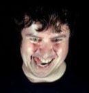 guy from an image i found that said "Faces of gamers pumped with dopamine". he's facing down and his expression is machiavellian. hes got his tongue out and looks sweaty.