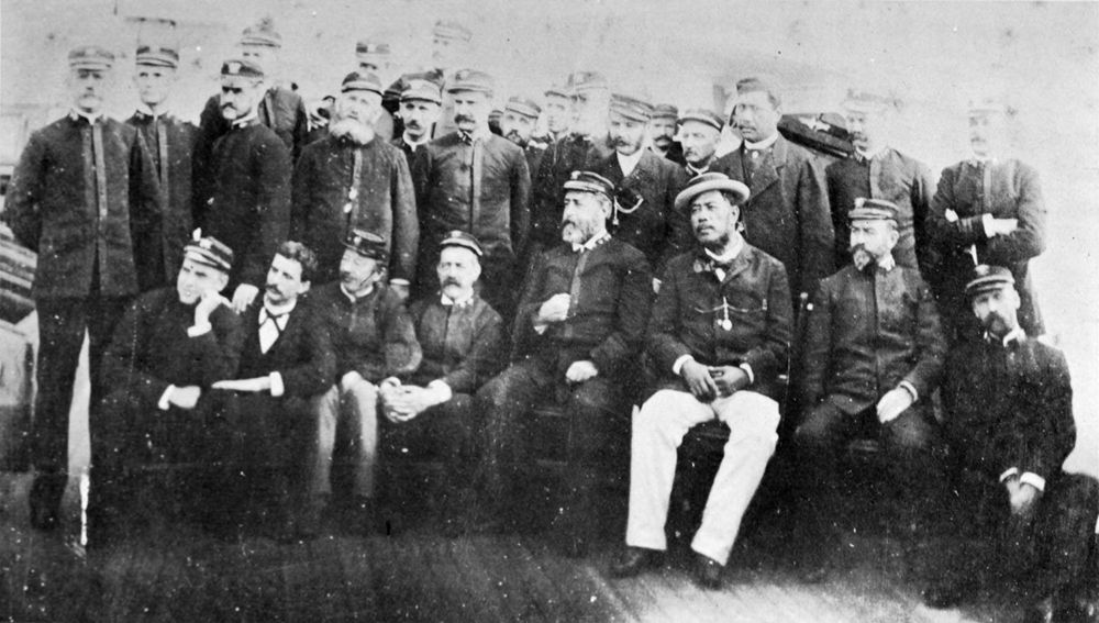 Photo of King David Kalākaua among a group of men on the USS Charleston.