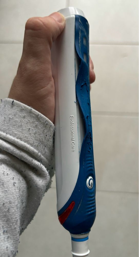 Das Antriebsteil einer elektrischen Zahnbürste, dessen Gummierung sich abgelöst und teilweise aufgelöst hat.