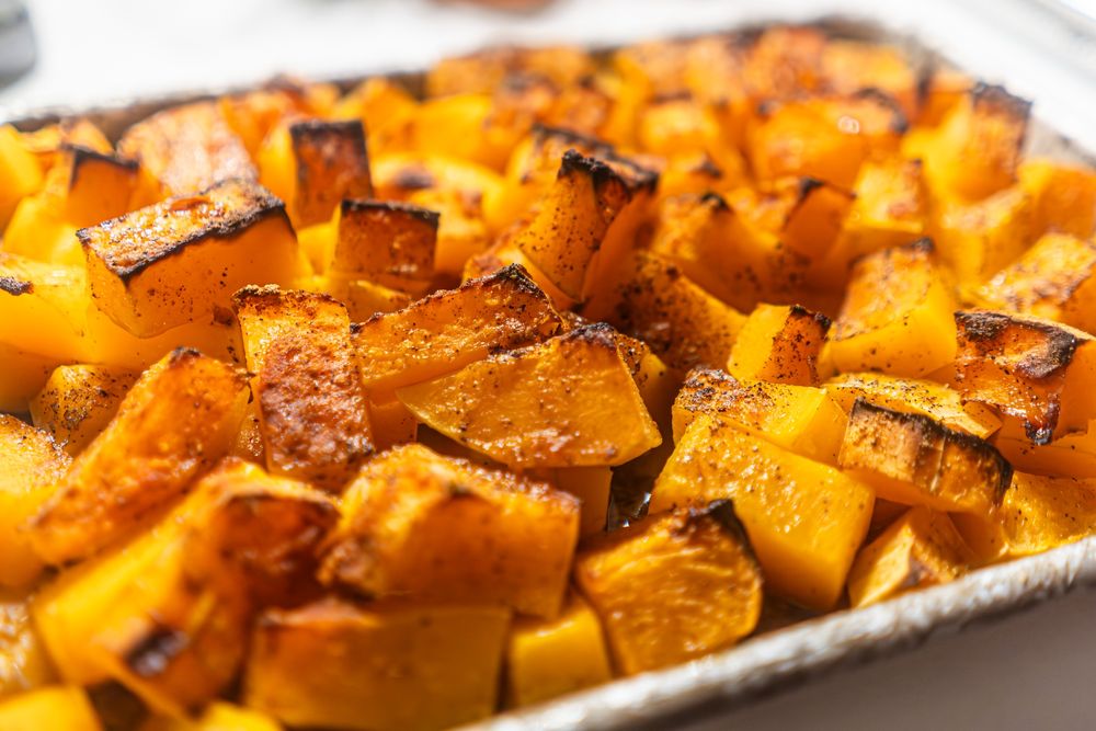 close up photo of chunks of roasted butternut squash on a sheetpan