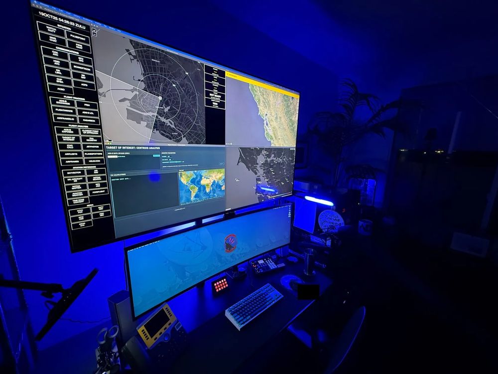 photo of an ultrawide "battle station" type home office setup with blue backlighting and a large television above the main monitor

a keyboard, desk phone and other desk accessories/peripherals are visible on the dark desk
