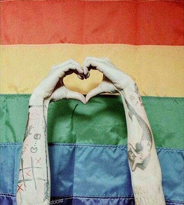 Harry Styles’ and Louis Tomlinson’s hands form a heart over a rainbow flag

Credit to the creator!