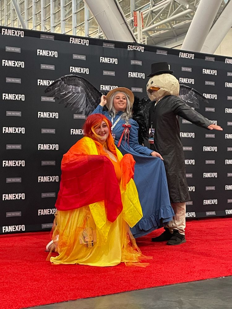 Image of three cosplayers dressed as Calcifer, Sophie and Turnip Head from Howl's Moving Castle