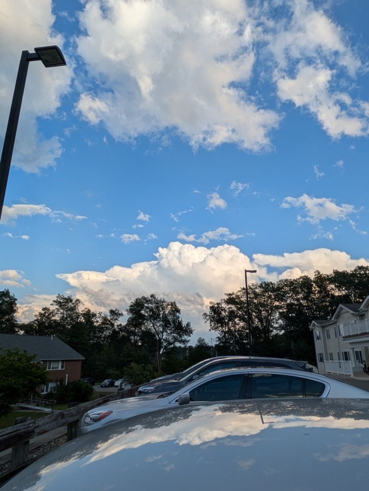 Fluffy white clouds against a bright blue sky.