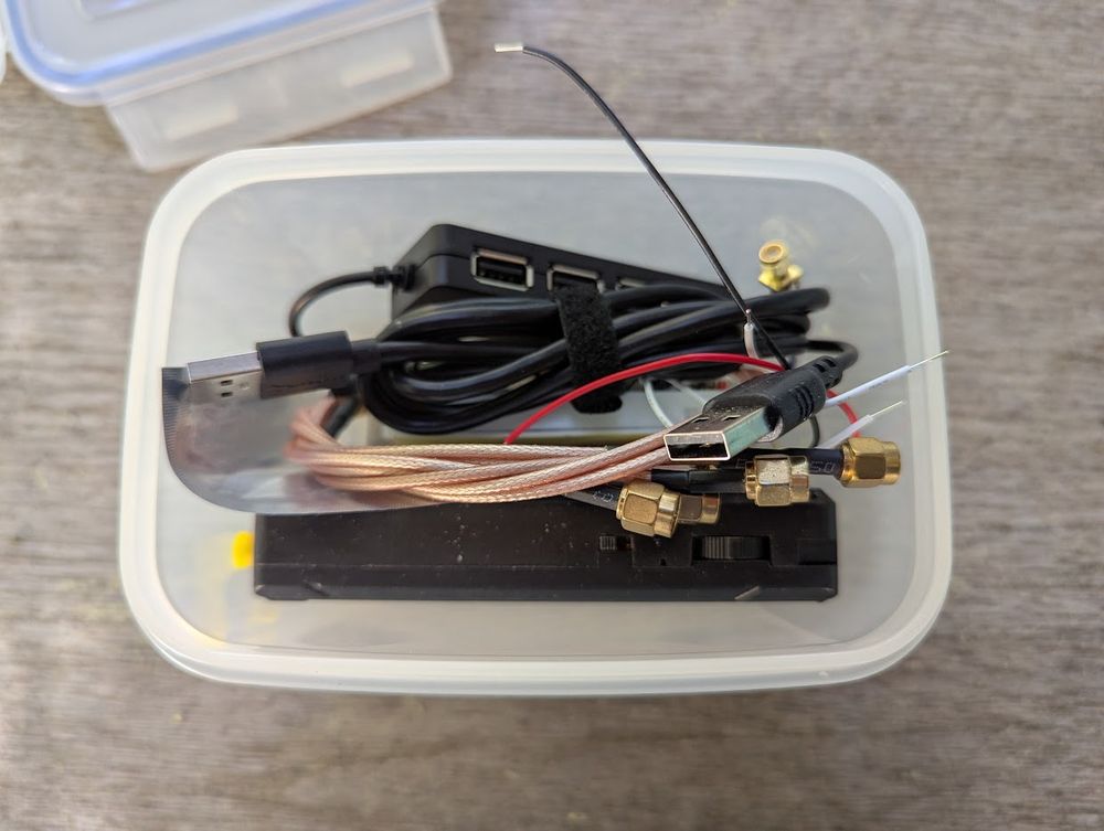 The box is open and you can see a USB cable, wires and some coax cables.