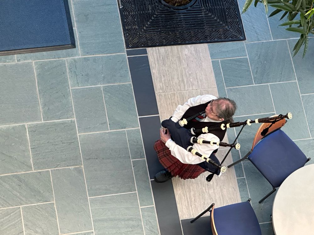 View from above as a bagpiper plays inside an atrium