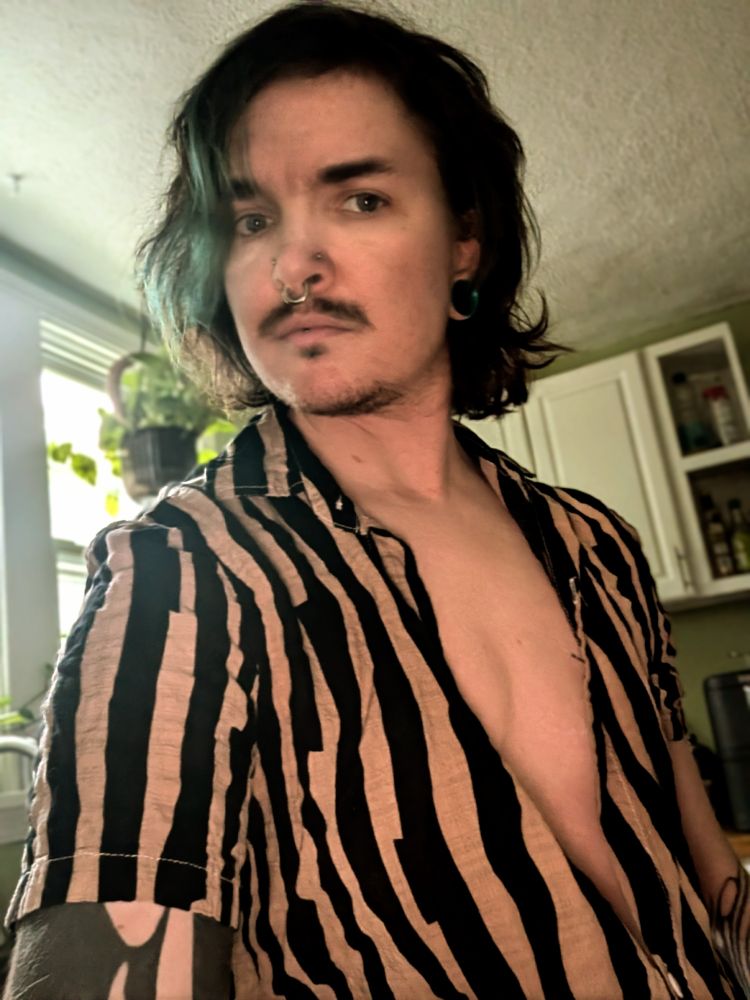 My with a striped button down shirt that's open to show my chest 