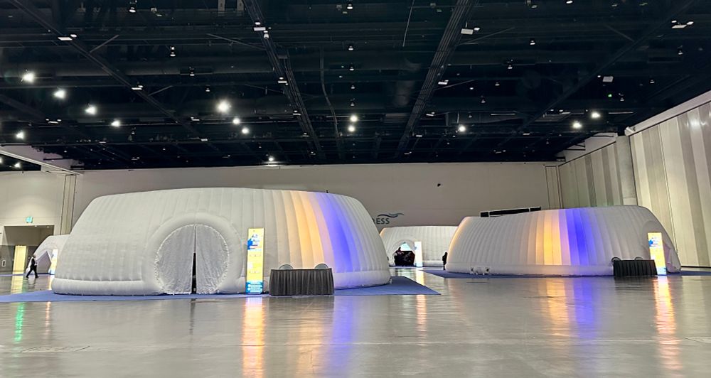 White enflatable bubbles host talks in the big halls of the convention center