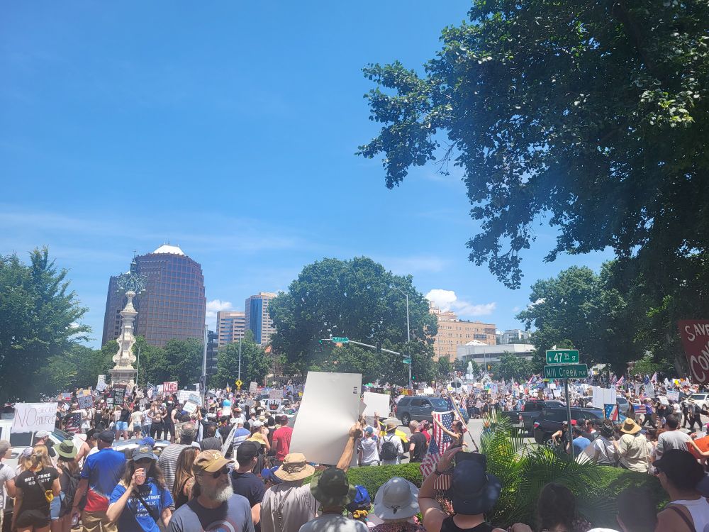 A photo of the crowd at the No Kings rally in Kansas City, Missouri. There is a large crowd, many holding signs protesting the actions of the president