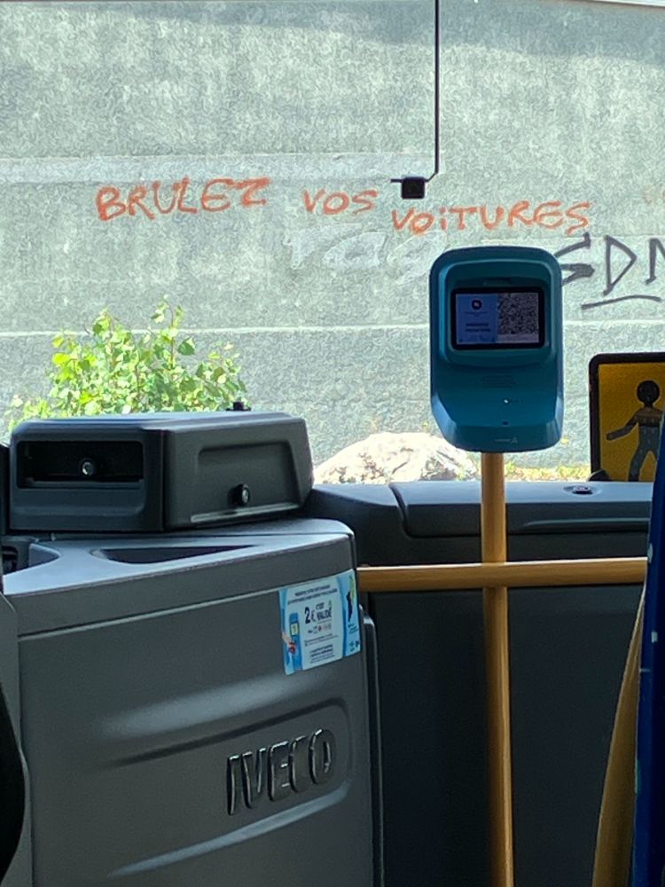 Through the window of a bus "Brulez vos voitures" (burn your cars)