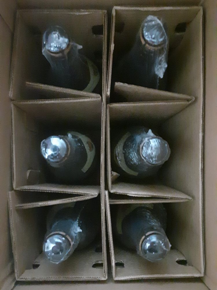 Caixa de papelão com seis garrafas de lambrusco com divisórias entre as garrafas também de papelão