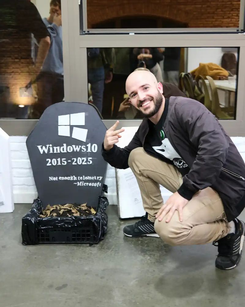 Ivan posando con la lápida de Windows 10 falsa al estilo del meme del funeral de Green Arrow.