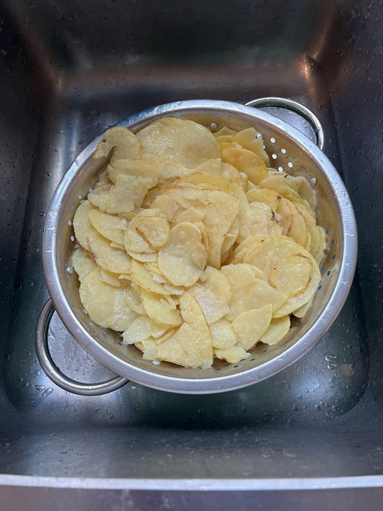 Drained crisps in a colander