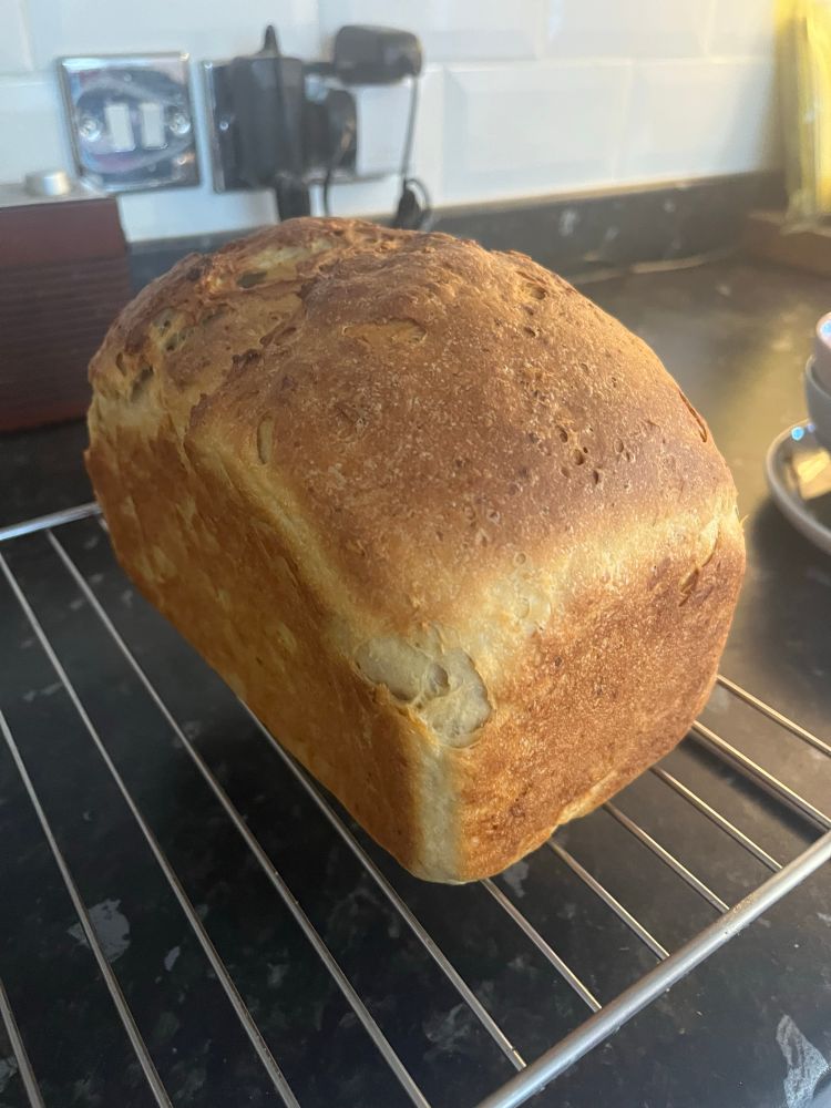 Bread out the oven cooling on a wire rack. Looks like a loaf of bread. The top is split which is annoying but not bad for a first go