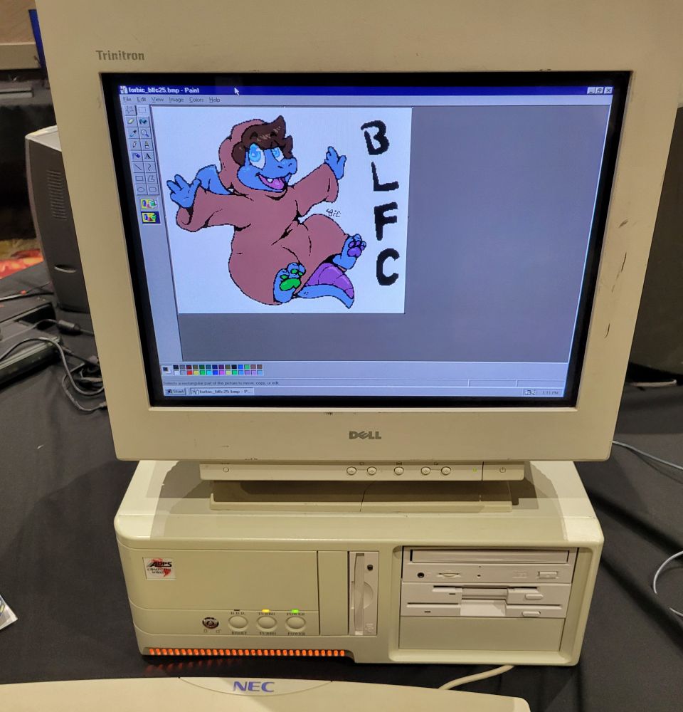 A happy little robed dragon on a computer with Windows 98