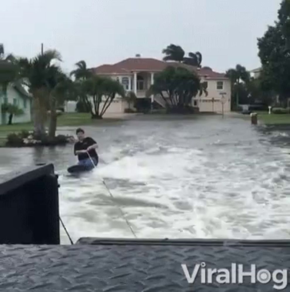 a man is riding a jet ski in a flooded area with the words viralhog on the bottom right