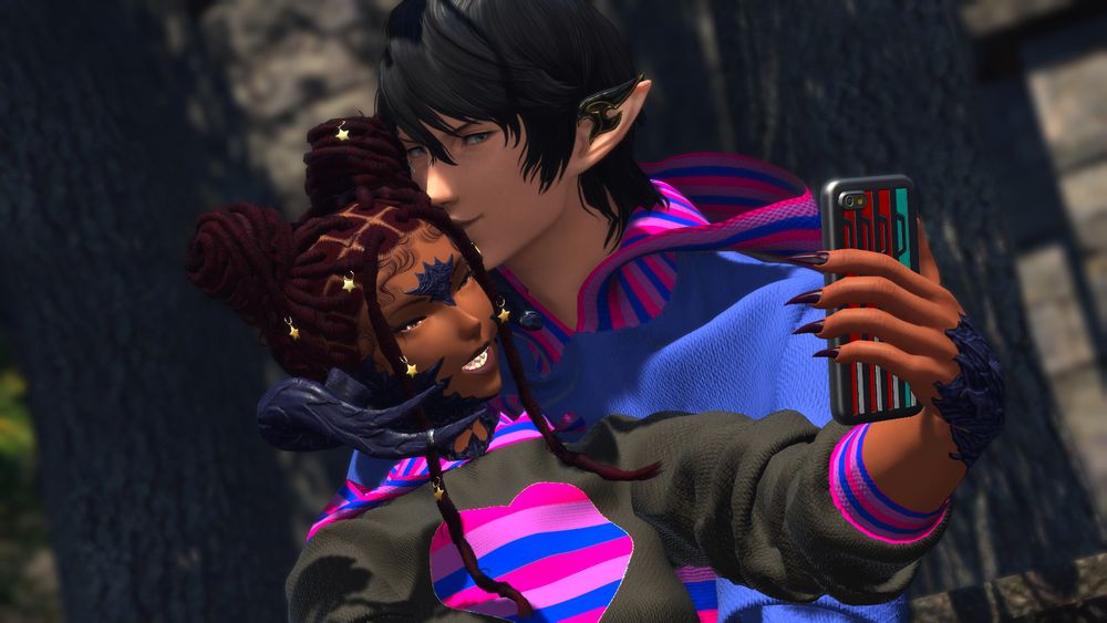 Avalan and Aymeric are cuddled together and smiling. Avalan is taking a selfie of both of them on her tomestone (phone) while he kisses her head.