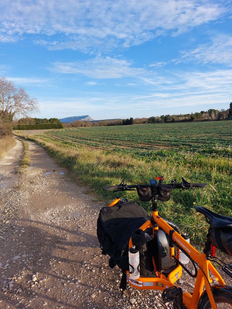 Velo cargo sur un chemin agricole avec la sainte Victoire en fond