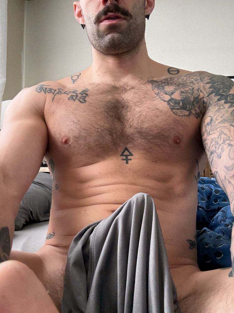 Photo of RJ sitting in bed with a great big tent between his legs 