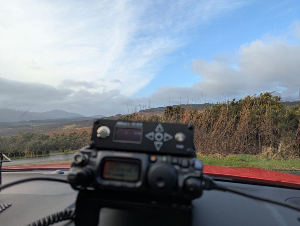 Morning radio operations on yaesu ft-818 looking out onto a scenic mountain view.