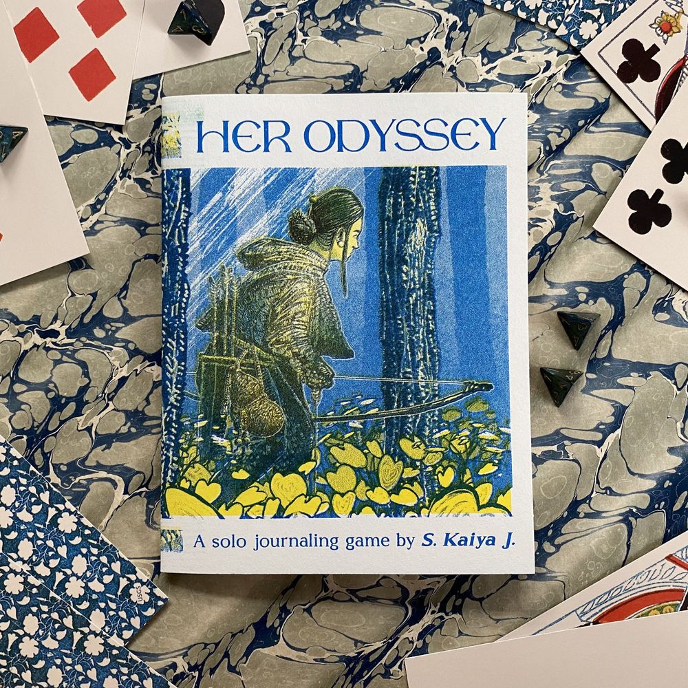 A print zine of Her Odyssey, a solo journaling game by S. Kaiya J., resting among poker cards and four-sided dice.