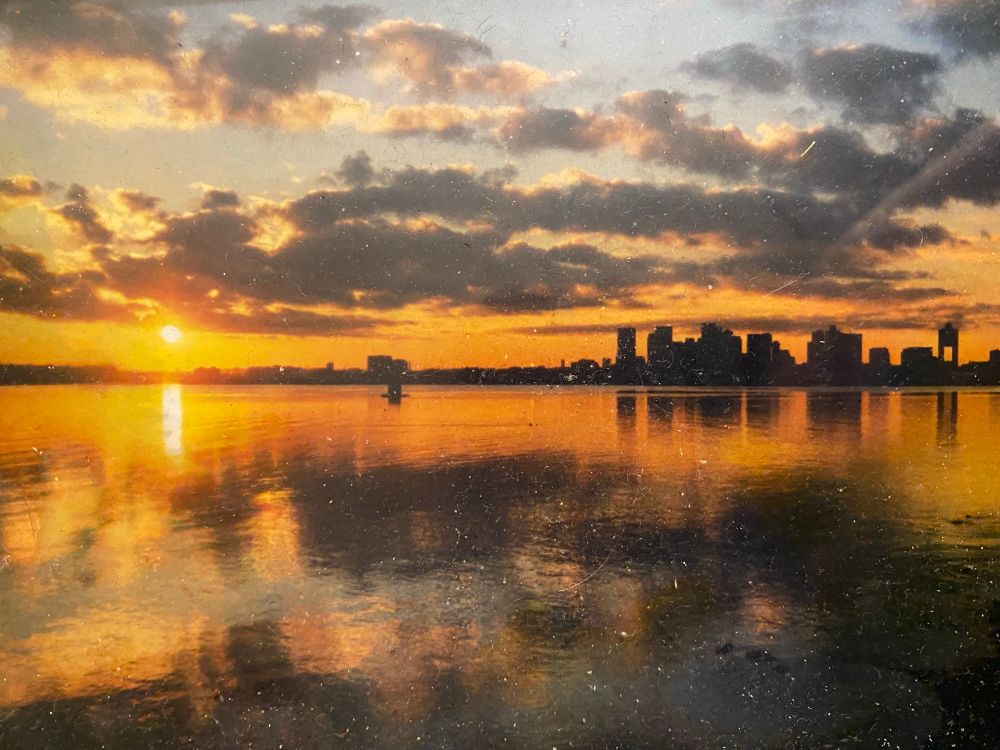 A view from Winthrop Massachusetts of the sun setting behind the Boston skyline, taken 25 years ago on December 31, 1999. 