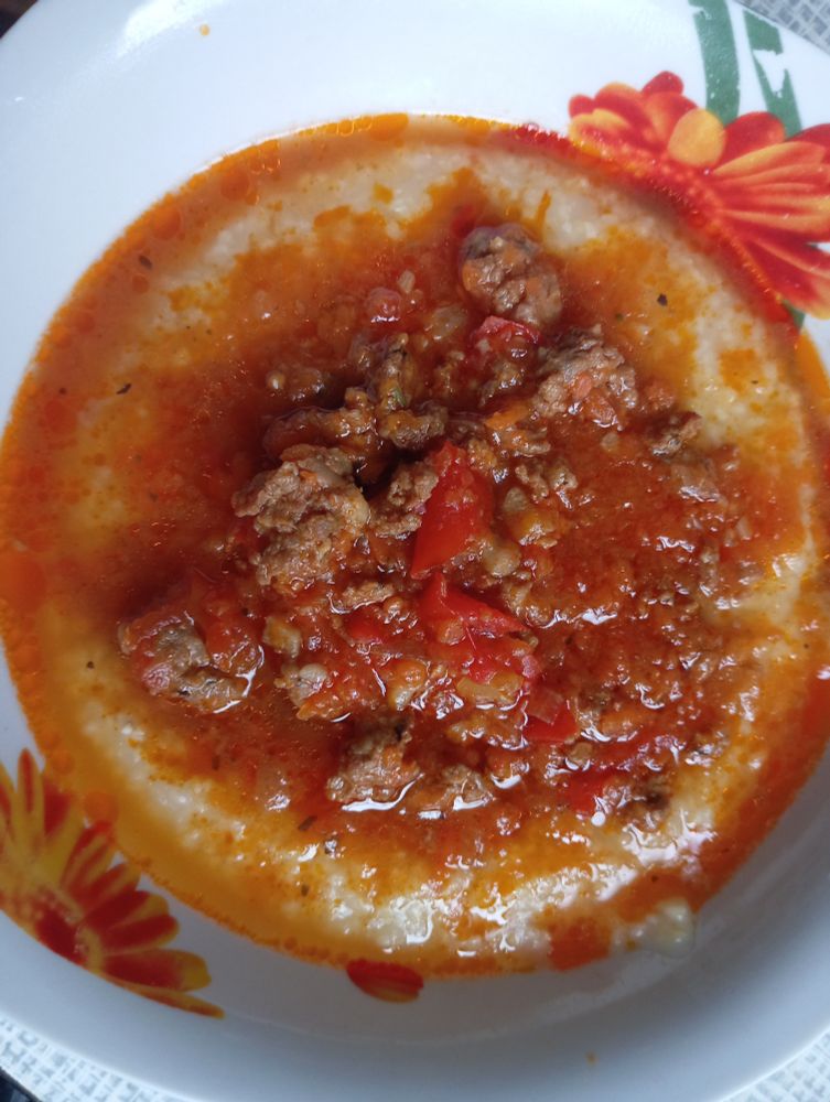A bowl of bolognese sauce with polenta. 
