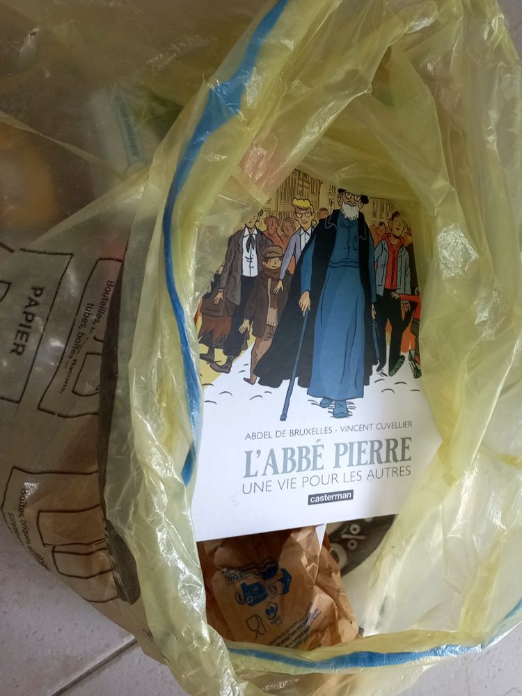 Une BD sur l'abbé Pierre dans un sac de recyclage papier