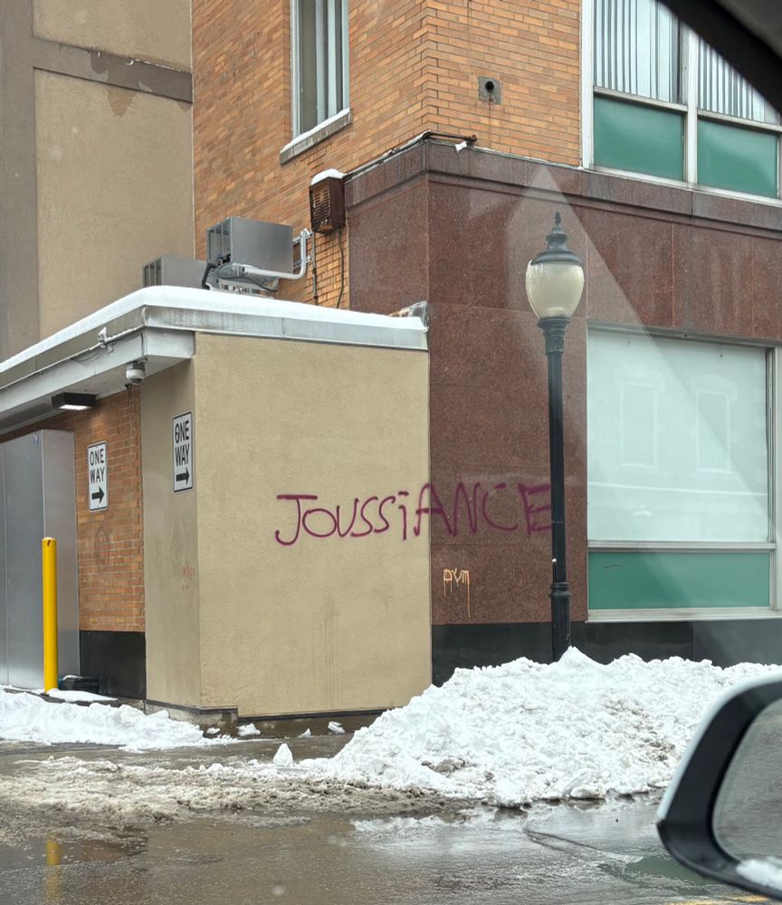 Graffito in red spray paint J-O-U-S-S-I-A-N-C-E