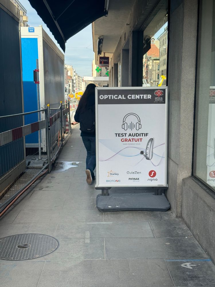 Un panneau de magasin qui bloque plus que la moitié du trottoir, déjà étroit à cause des travaux 