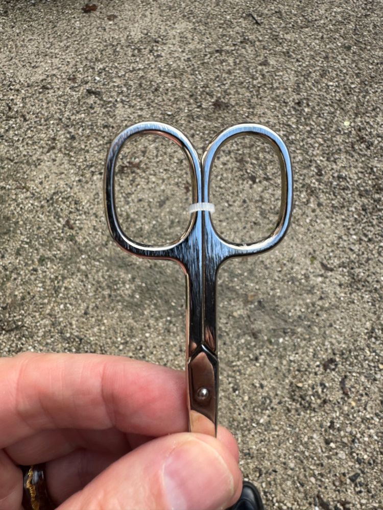 A pair of scissors with a zip tie holding the finger ends together. To make them usable, a pair of scissors is required. 