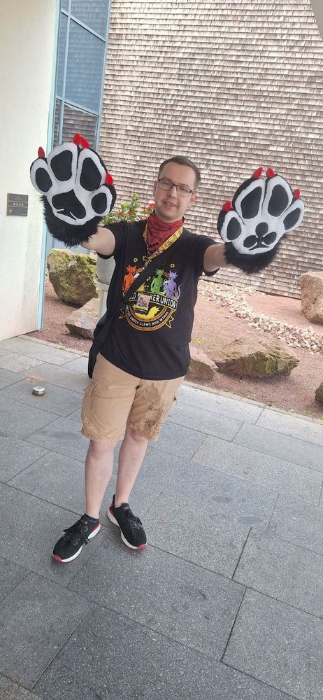 A photo of me wearing my auction bought plush paws with a card game design (A spade and clubs symbol are visible on the palms)