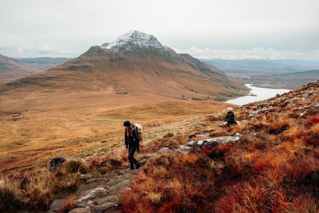 Two people walking on a hillside in rural scotland
