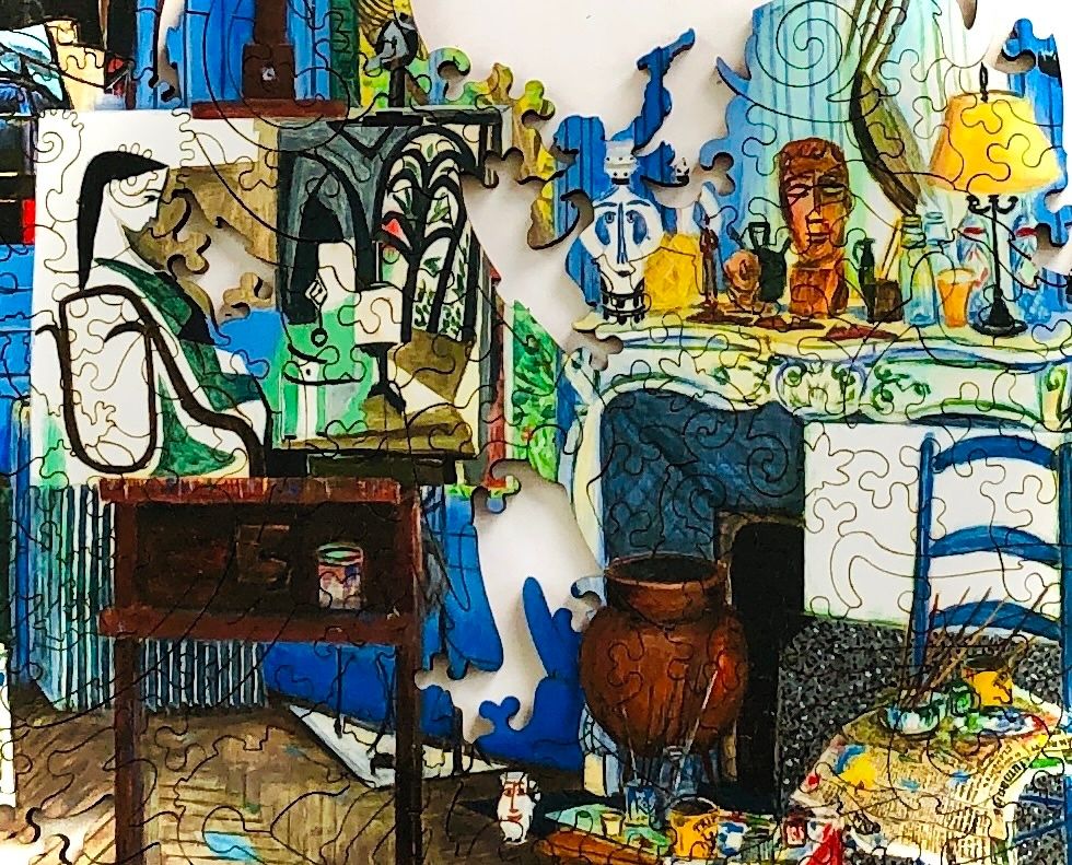 This is a portion of a puzzle in progress (Picasso's studio from Liberty Puzzles). In this partially finished section, a woman in a painting is faced with a missing piece, an empty space, and there's a whimsically shaped puzzle piece in the center that looks a bit like a small figure painting the scene from within. 