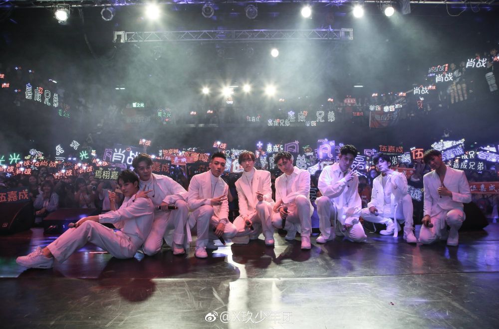 Photo of X-Nine posing at their 520 showcase in 2018. Xia Zhiguang has his arm around Xiao Zhan.