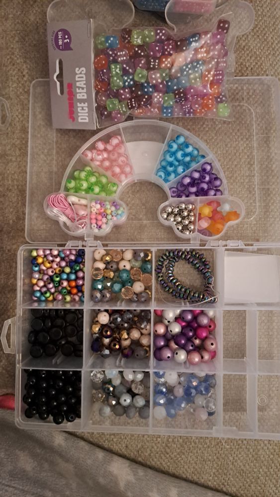 Bag of different colored dice shaped beads. An assortment of different colored and sized, mostly round beads in various colors, including black, blues and purples