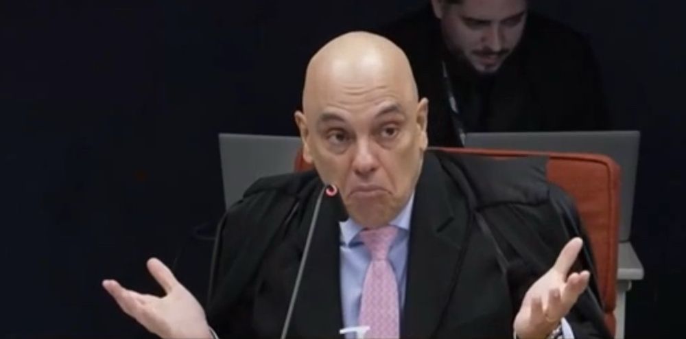 Ministro Alexandre de Moraes levanta as mãos como se indagasse algo. 
