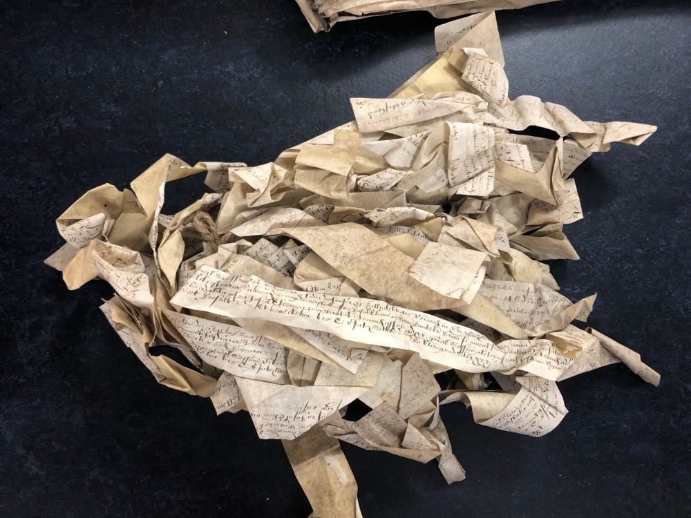 Isle of Ely recognisances, 1662. A bundle of thin parchment strips tied at one end. They are written in Latin