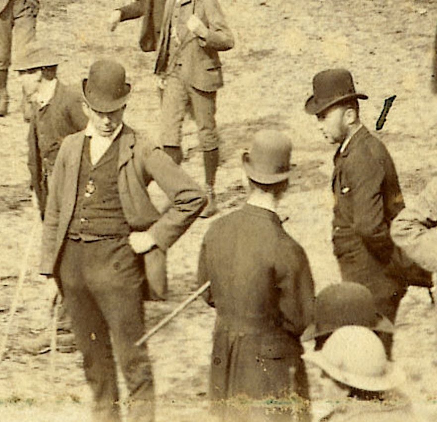 A close-up of some of the people at the Cattle Market. They are wearing bowler hats, waistcoats and smart coats, and are carrying canes. (Doc ref PH68/14 part)