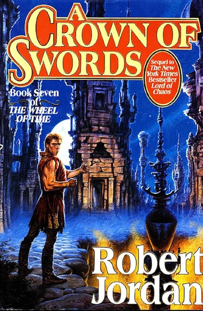 The image shows the book cover of "A Crown of Swords" by Robert Jordan, which is Book Seven in "The Wheel of Time" series. The cover features fantasy artwork depicting a man in medieval-style clothing holding a sword, standing against a backdrop of dark stone architecture and blue lighting. The title is displayed in ornate yellow lettering at the top,