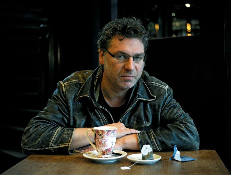 Olifr M. Guz mit einer Tasse in einem Café